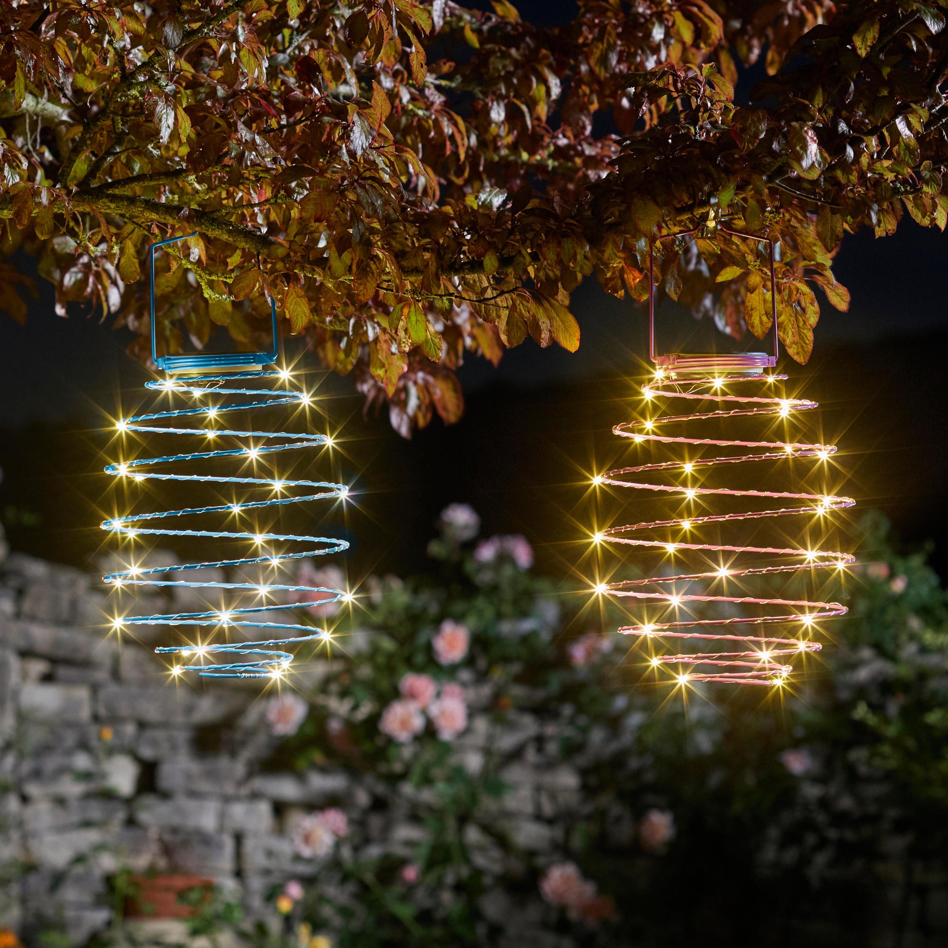 V záhrade svietiaca modrá a rúžová dekoračná špirála Solar Spiral Light od The Outdoor Living Company